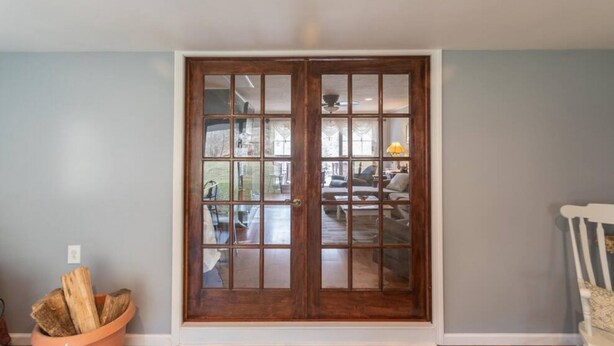 A room with a large wooden door, a terracotta pot with logs, and a white chair. - Amazing Hiking Cozy Home Close to Mountns Fireplace (Prattsville)