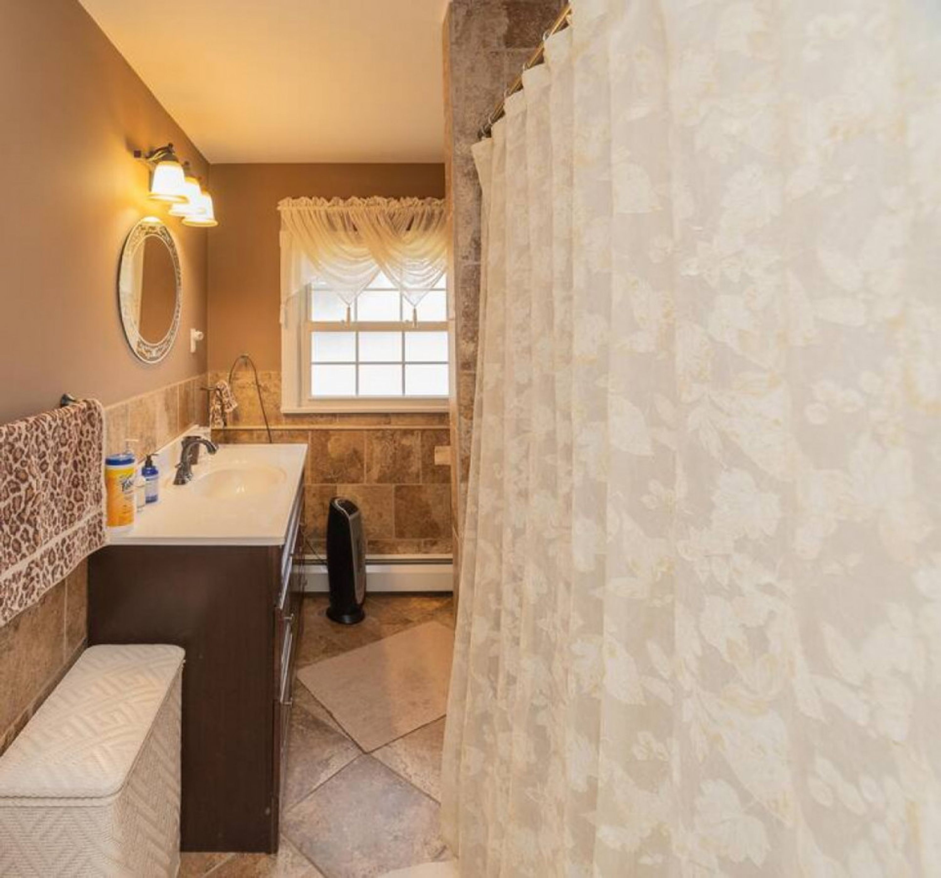 Une salle de bain équipée d’un lavabo, d’un miroir et d’un espace douche.
