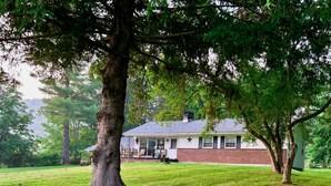 A house with a brick exterior, a covered porch, and a lawn. - Amazing Hiking Cozy Home Close to Mountns Fireplace (Prattsville)