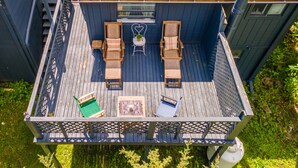 A deck with outdoor furniture, a small table, and a chair.