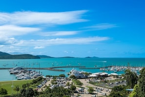 A marina with boats, a parking area, and a view of the coastline.