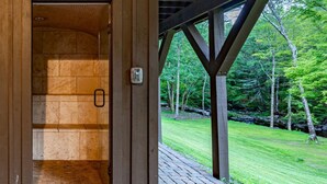 A wooden structure with a glass door leading to a tiled room. - Family Fun Oasis Hot Tub Steam Room Pool Stream Firepit Games (Saugerties)