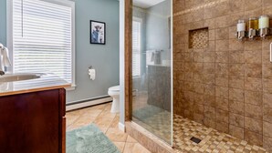 A bathroom with a shower, toilet, and sink. - Family Fun Oasis Hot Tub Steam Room Pool Stream Firepit Games (Saugerties)