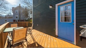 A wooden deck with a table and chairs, a blue door, and a small grill. - Cozy Easy Access to the Best of the Hudson Valley (Cornwall)