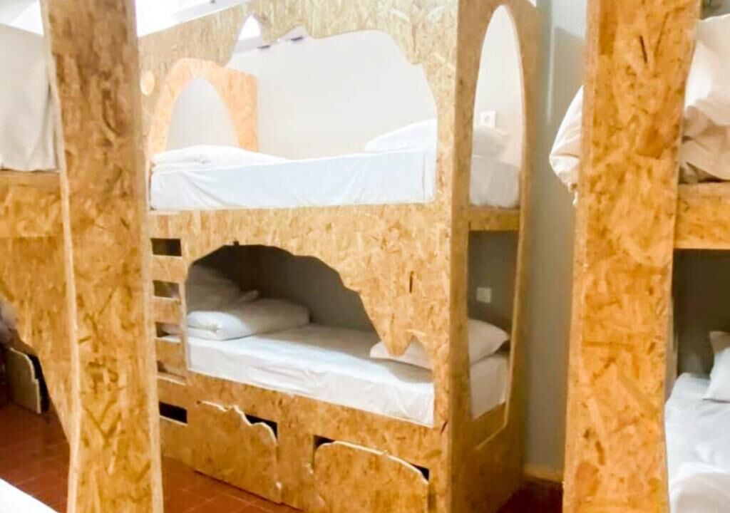 Habitación con literas de madera, con una litera inferior y otra superior con dosel.