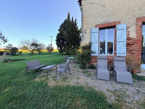 Un edificio rustico con un patio giardino e posti a sedere all'aperto.