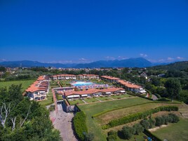 Ein Resort mit mehreren Gebäuden, einem Schwimmbad und einem gepflegten Rasen.