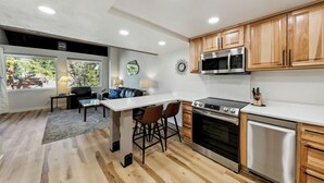 A modern kitchen with wooden cabinets, a stainless steel oven, and a microwave. - Lakeland Village #309 Luxury Remodel 1BR+Loft (South Lake Tahoe)