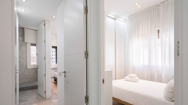 Ein modernes Hotelzimmer mit Bett, Badezimmer und Küchenzeile.