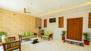 A living room with a sofa, chairs, a coffee table, and a ceiling fan. - Treebo Grand Royal Imperio, Hinjewadi (Paud)