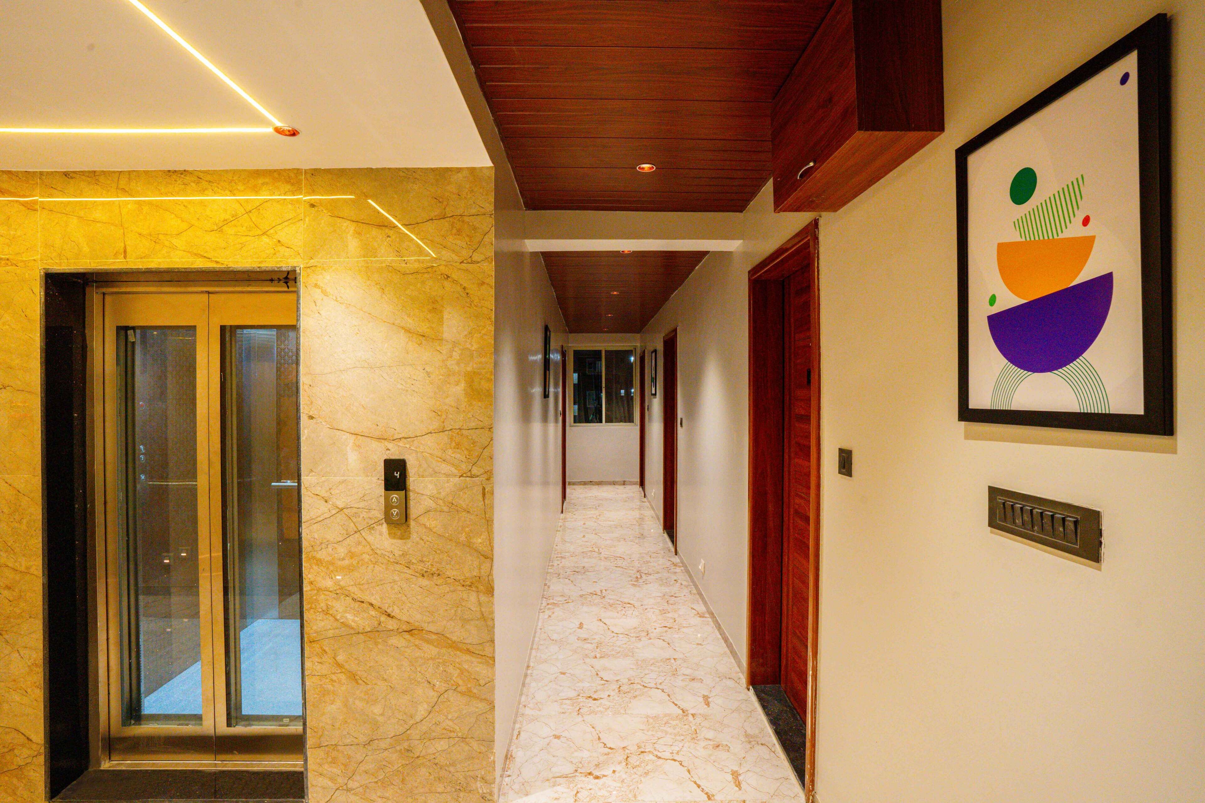 A hallway with marble flooring, wooden doors, and a framed abstract artwork on the wall.
