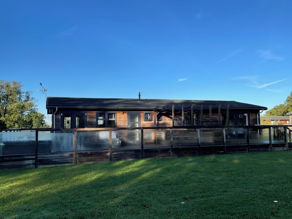 Ein modernes Gebäude mit flachem Dach, großen Fenstern und einer Holzfassade.