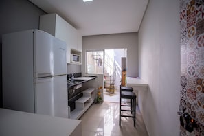 Geladeira grande, micro-ondas, talheres/pratos/utensílios de cozinha