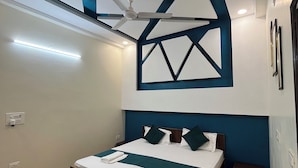 Un dormitorio moderno con una cama, un ventilador de techo y un diseño geométrico en la pared.