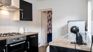 A modern kitchen with a gas stove, oven, and a black refrigerator. - 3br-7guests-freeparking-pets-towncentre (Stoke-on-Trent)