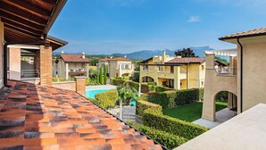 Un quartiere residenziale con piscina, giardini curati e vista sulle montagne.
