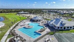 Un resort con una piscina grande, varias construcciones y un césped bien cuidado.