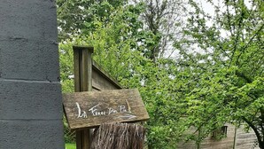 A rustic outdoor area with a wooden sign reading "La Ferme Des Pins" and a straw bale structure. - La Ferme des Pins, relaxation with family and friends, 15 minutes from the beach (Carly)
