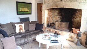 A cozy living room with a fireplace, a sofa, and a coffee table. - La Ferme des Pins, relaxation with family and friends, 15 minutes from the beach (Carly)