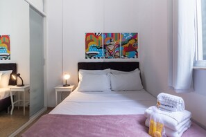 A hotel room with a bed, a nightstand, a lamp, a painting on the wall, and a window with curtains. - 3 Minutes From Copacabana Beach Du705 (Rio de Janeiro)