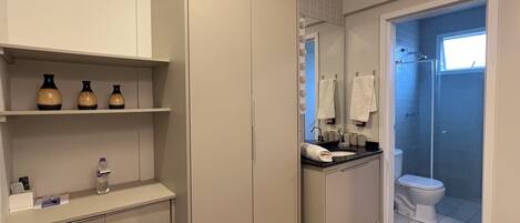 A modern bathroom with a vanity, mirror, and shower.