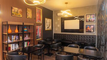 Un restaurante con cabinas, mesas y sillas. Se observan estanterías con libros y objetos decorativos.