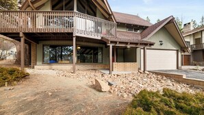 A two-story house with a balcony, a garage, and a stone foundation.