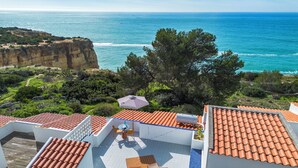 A rooftop terrace with terracotta tiles, outdoor furniture, and a view of the ocean. - Ocean View Apartment with rooftop terrace (Carvoeiro)