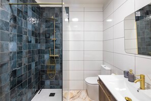 Regadera, secadora de cabello, toallas, papel de baño 