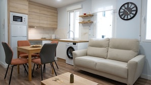 A compact living space with a kitchenette, a dining area, and a seating area.