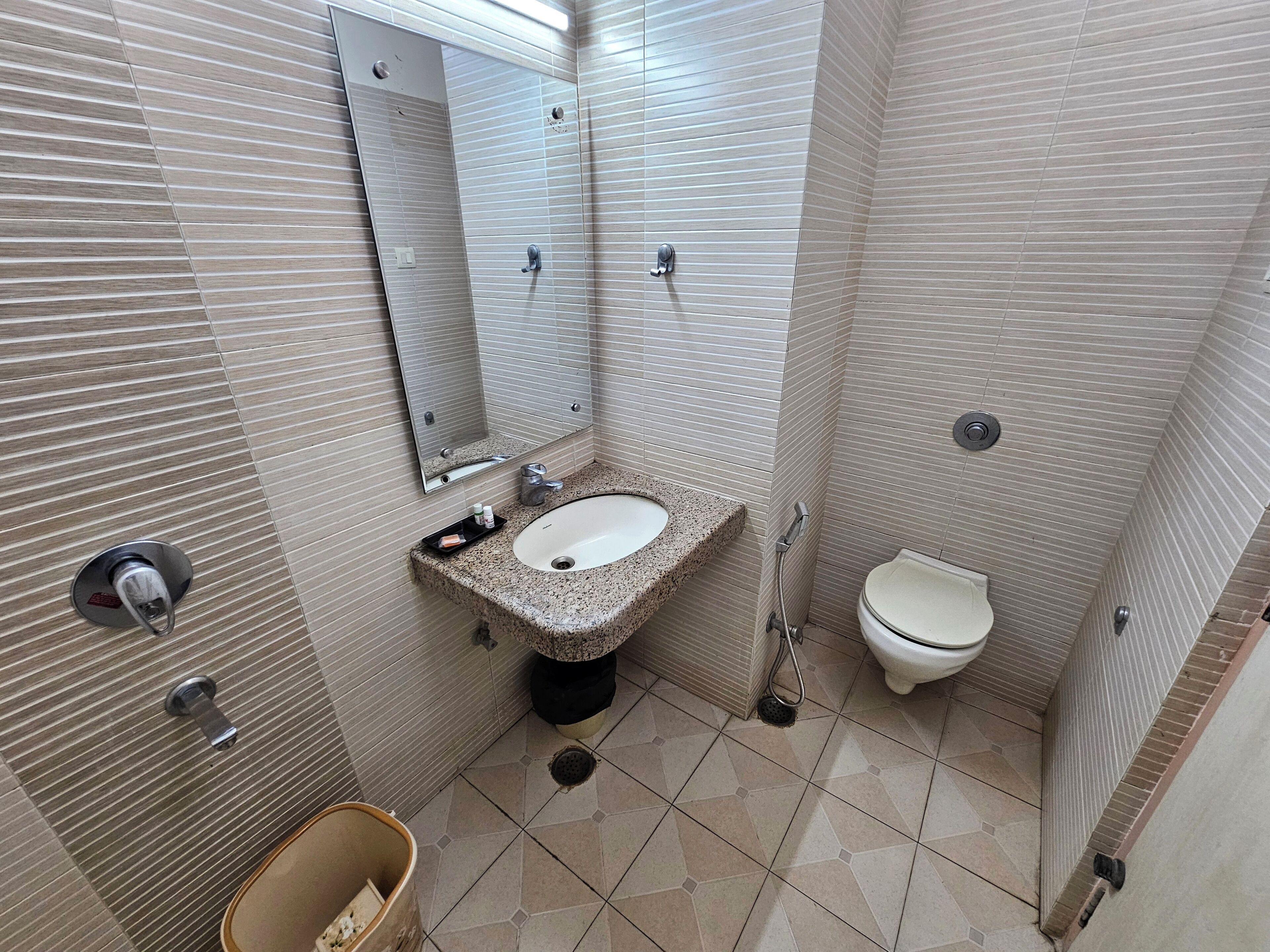 A small bathroom with a sink, toilet, and mirror.