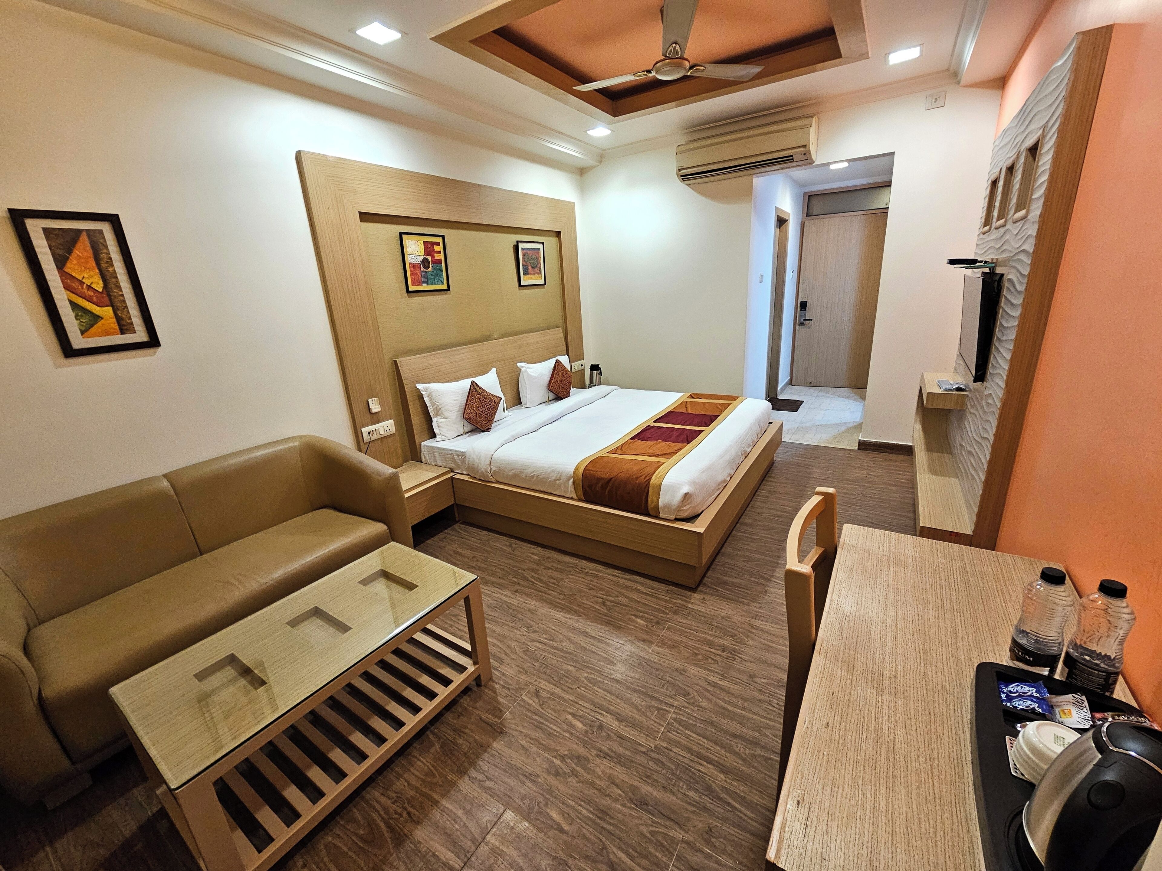 Une chambre d’hôtel avec un lit, un canapé, un bureau et une télévision.