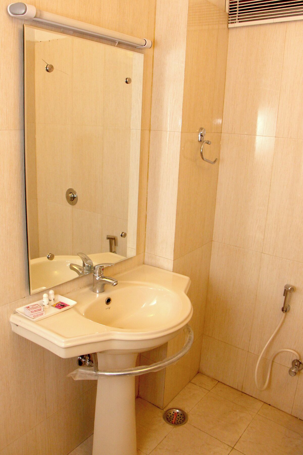 A bathroom with a sink, mirror, and shower.