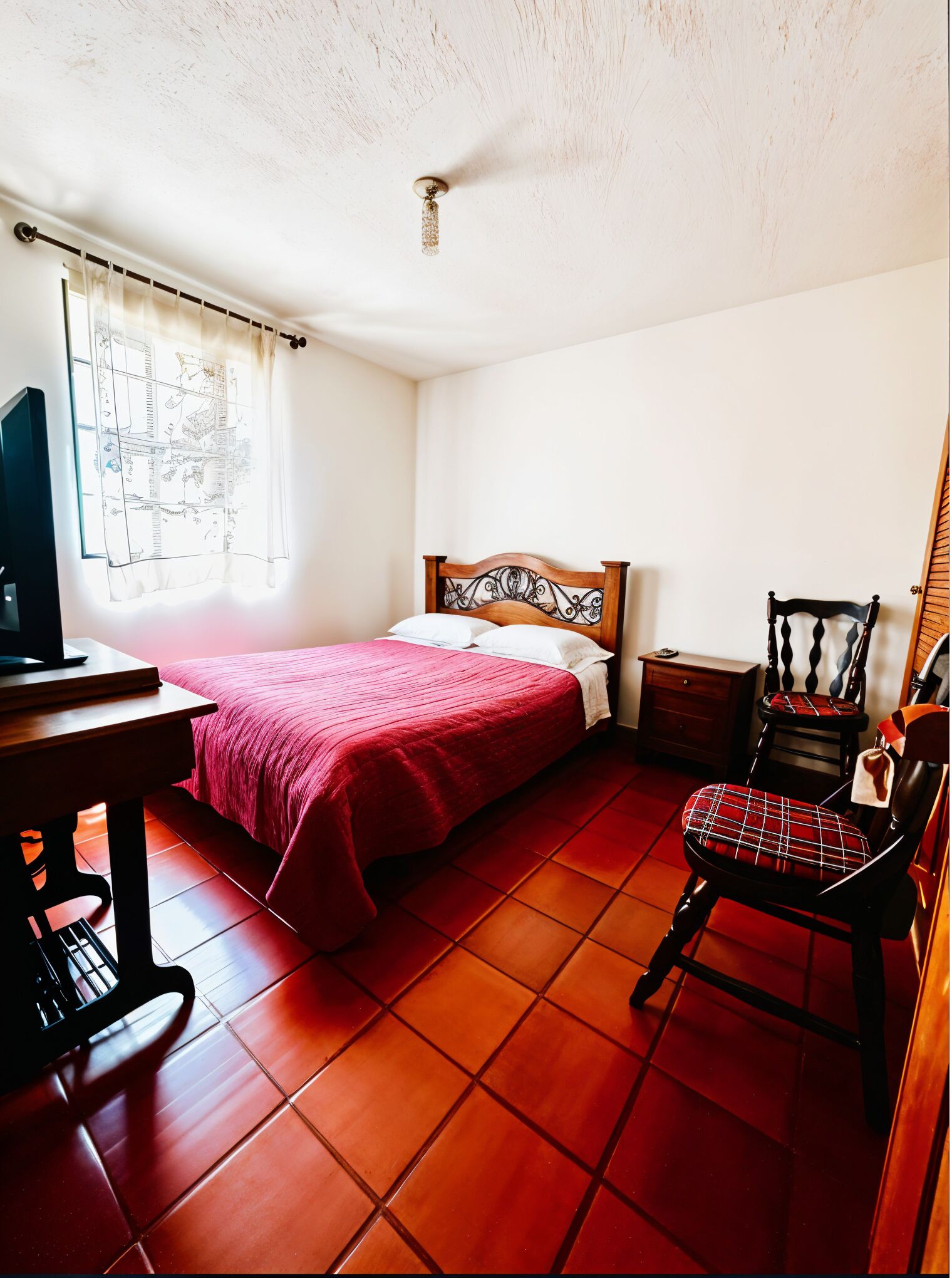 Een slaapkamer met een bed, een stoel, een bureau en een raam met gordijnen.