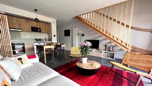 Un espace de vie moderne comprenant une cuisine, un coin repas et un escalier.
