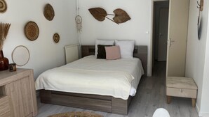 Un dormitorio con cama, mesita de noche y adornos en la pared.