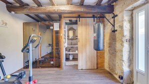 A room with a wooden floor, a punching bag, a treadmill, and a mirror. - Villa Pauill'art - Marco Polo  (Pauillac)
