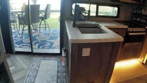 A compact kitchen with a sink, stove, and microwave. - Ocean Front Paradise @ Sea Beach (Aguada)