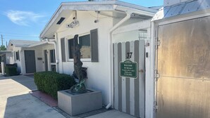 A building with a gated entrance, a welcome sign, and a statue.