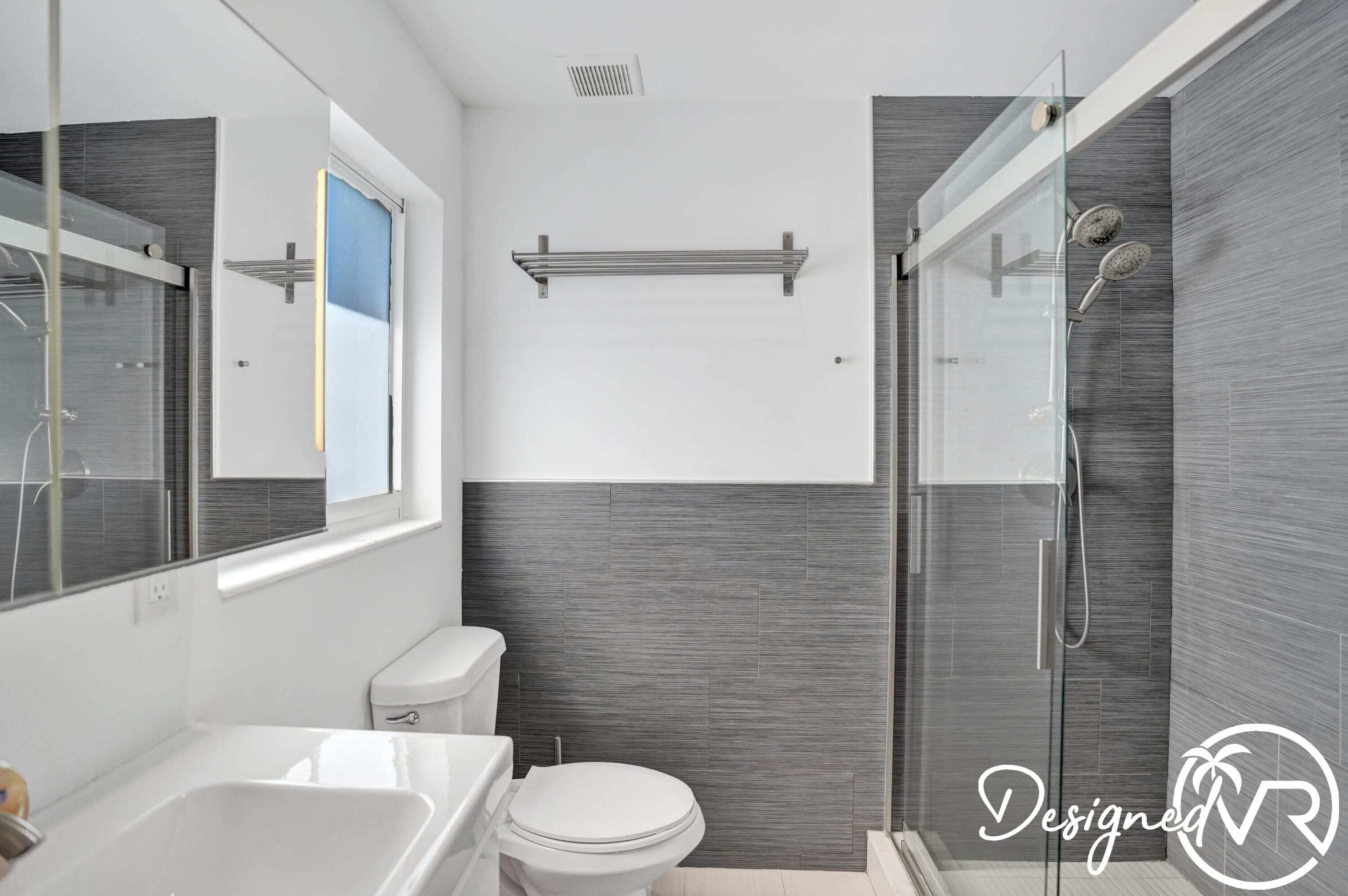Une salle de bain moderne avec une douche à parois de verre, des toilettes blanches et une baignoire.