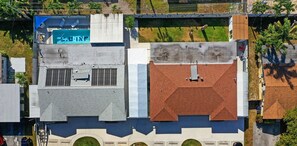 Vista aérea de un edificio con piscina, múltiples ventanas y una azotea con chimenea.