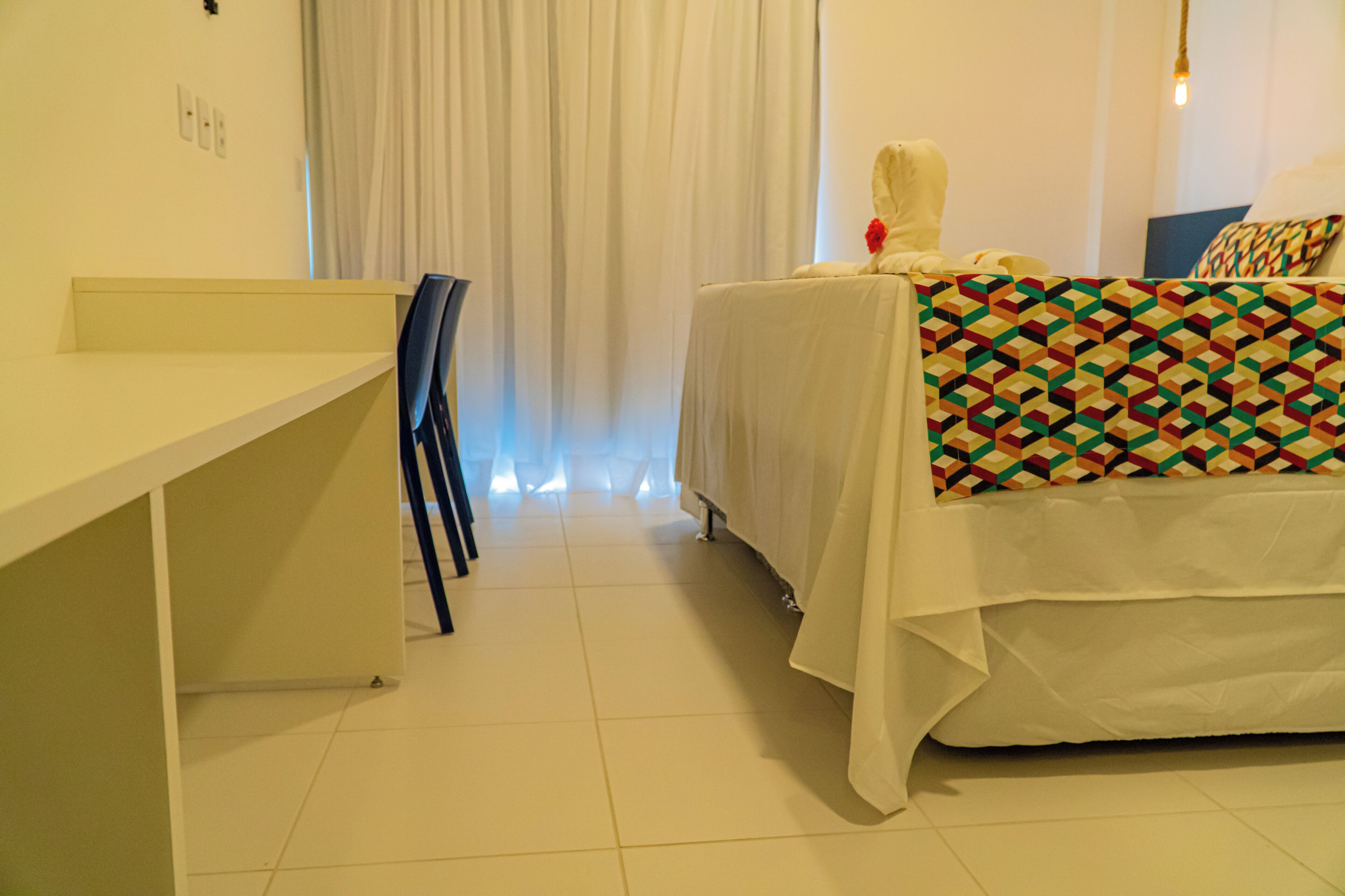 Een hotelkamer met een bed, een bureau en een stoel.