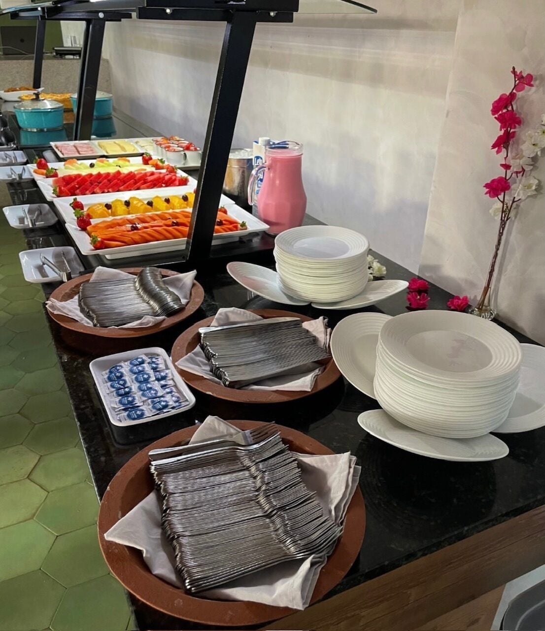 A buffet setup with various food items and utensils.