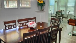 Ein Essbereich mit einem Holztisch und Stühlen, einer Vase mit Sonnenblumen und einer Kandelaber.