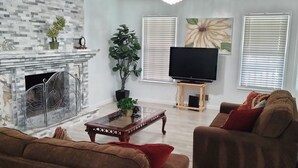 Ein Wohnzimmer mit Kamin, Fernseher und zwei Sofas.