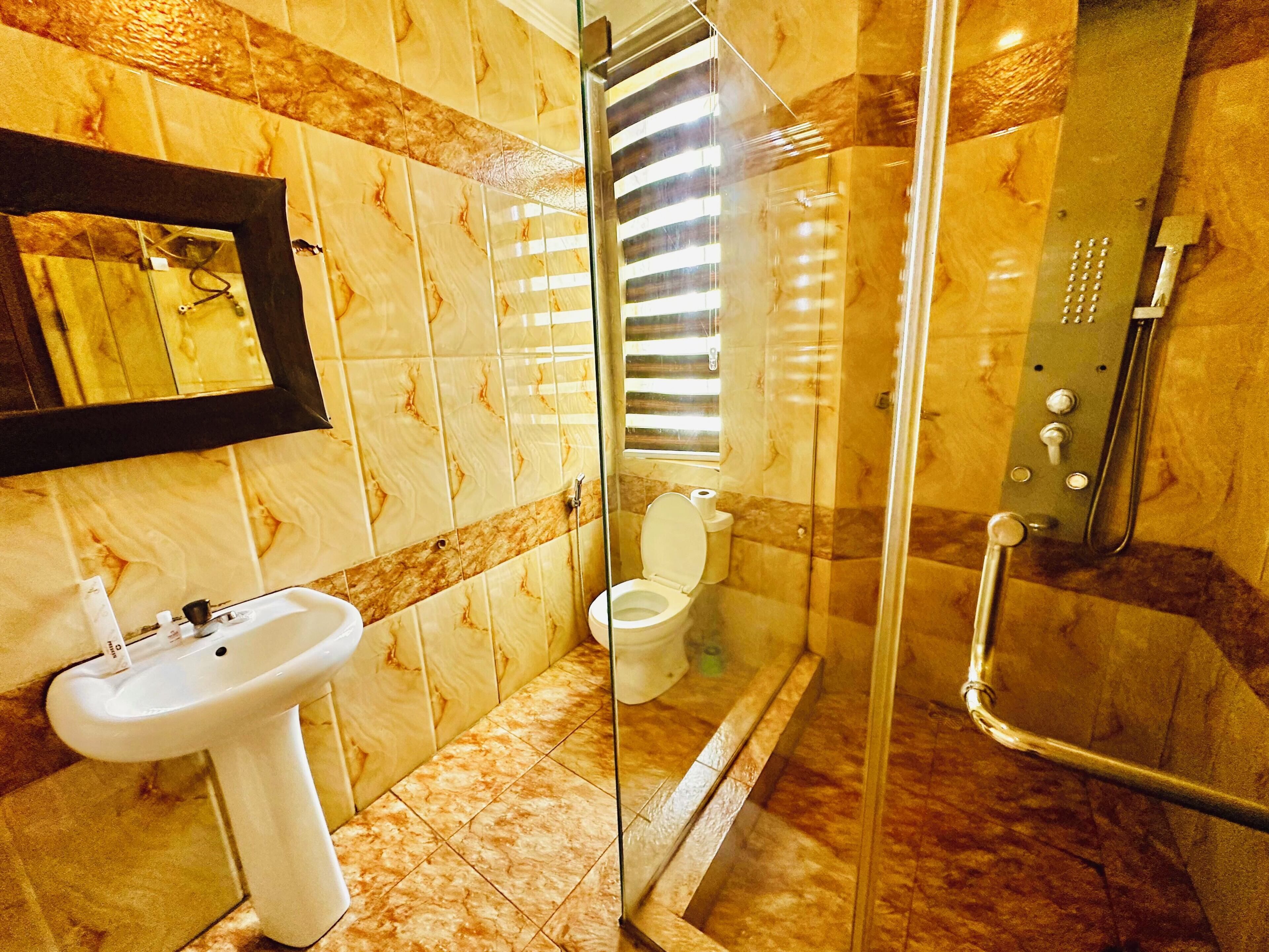 Bany amb dutxa de vidre, un lavabo i un vàter.