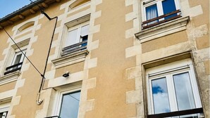 A building with multiple windows, some with shutters, and a visible balcony railing. - Town house 10 min from Futuroscope (Migné-Auxances)