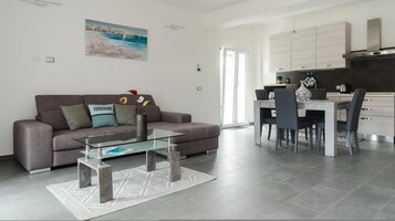 Una sala de estar moderna con un sofá, una mesa de centro y un cuadro en la pared.