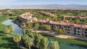 Een resort met meerdere gebouwen, een golfbaan en een meer.