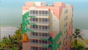 Un hotel de varios pisos con balcones, piscina y vistas a la playa.